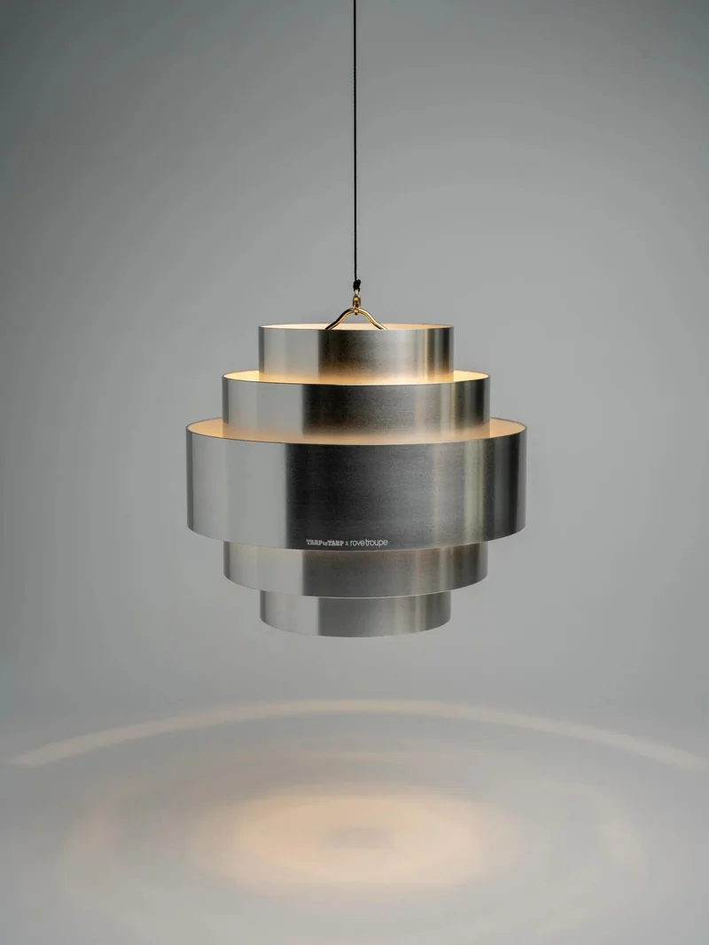 銀色 ECHO LAMP 懸掛在淺灰背景前並投下圓形光暈