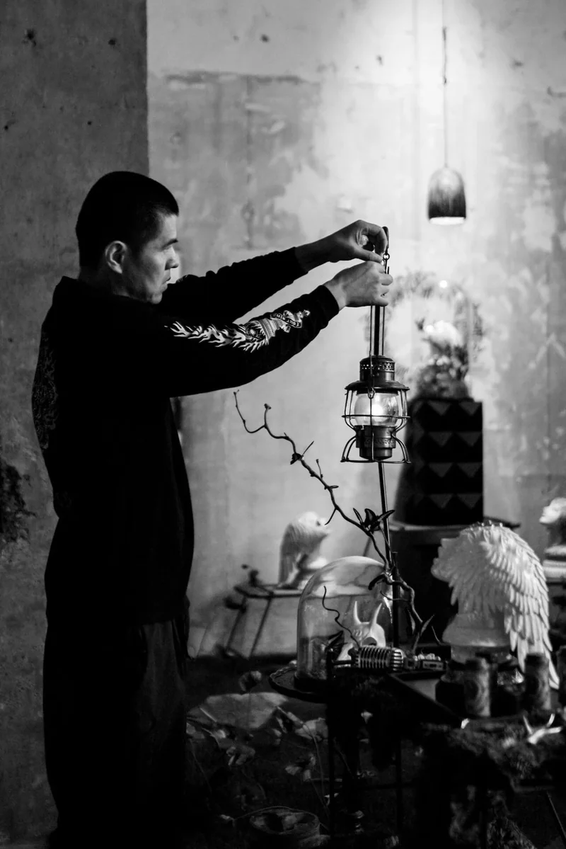 工作人員在陳列櫃前佈置 Filomela 作品的黑白照片