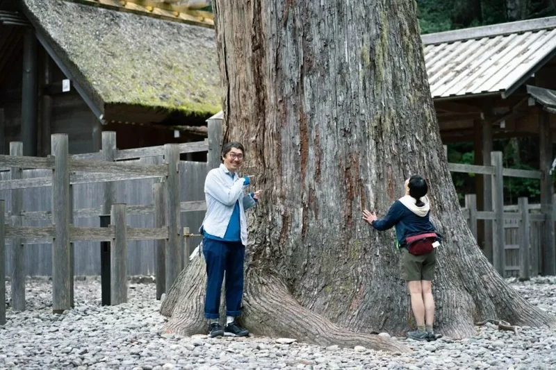 树木与神社建筑旁的旅行者