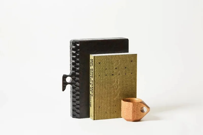 A JINCUP handle projects from the BOOKSUITS wooden book sleeve.
