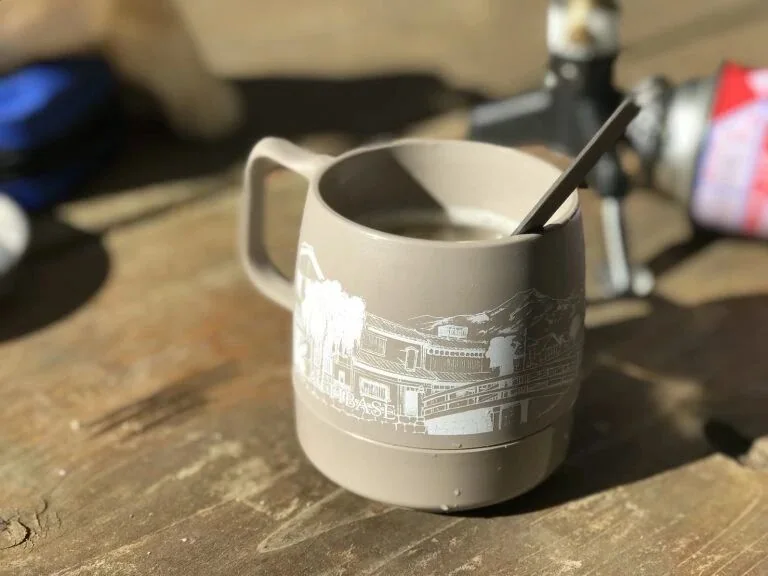 印有街景、山脈和登山者圖案的 DINEX 杯