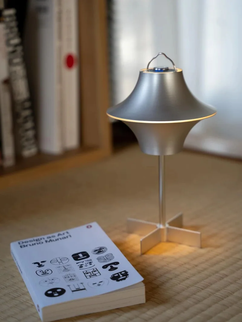 銀色 rove troupe 燈具與品牌說明冊陳列在室內木桌上