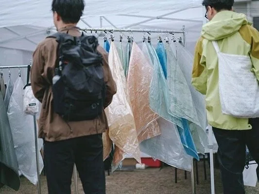 參觀者在帳篷展位挑選服裝