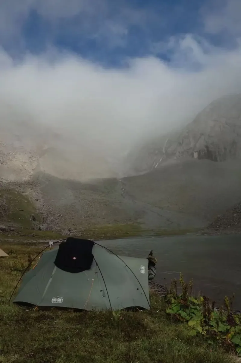 雾气笼罩的山间草地与帐篷