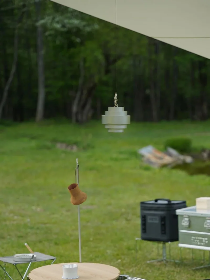 ECHO LAMP 安放在草地營位中,遠處是樹林和露營裝備
