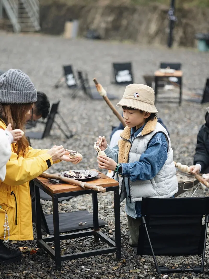 家长和孩子围在篝火旁参加直火料理