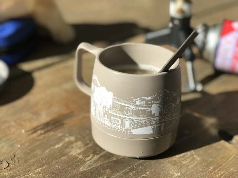印有街景、山脉和登山者图案的 DINEX 杯
