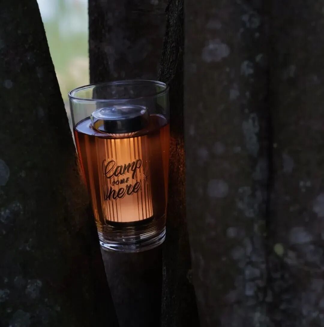 树林背景前装有饮品的《CHEERS!》玻璃杯