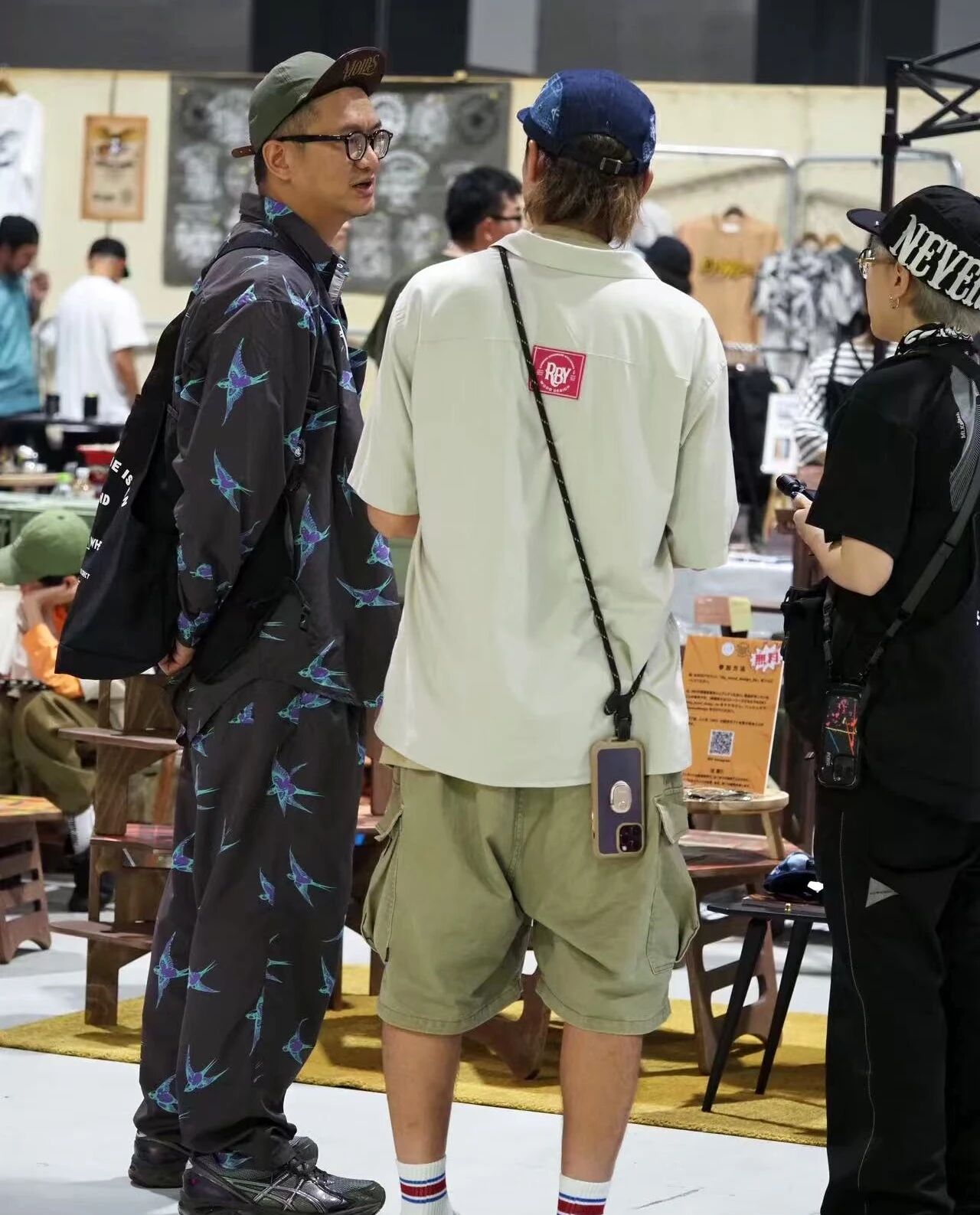 FIELDSTYLE 人群中有人穿着带燕子图案的 NATAL DESIGN 服装