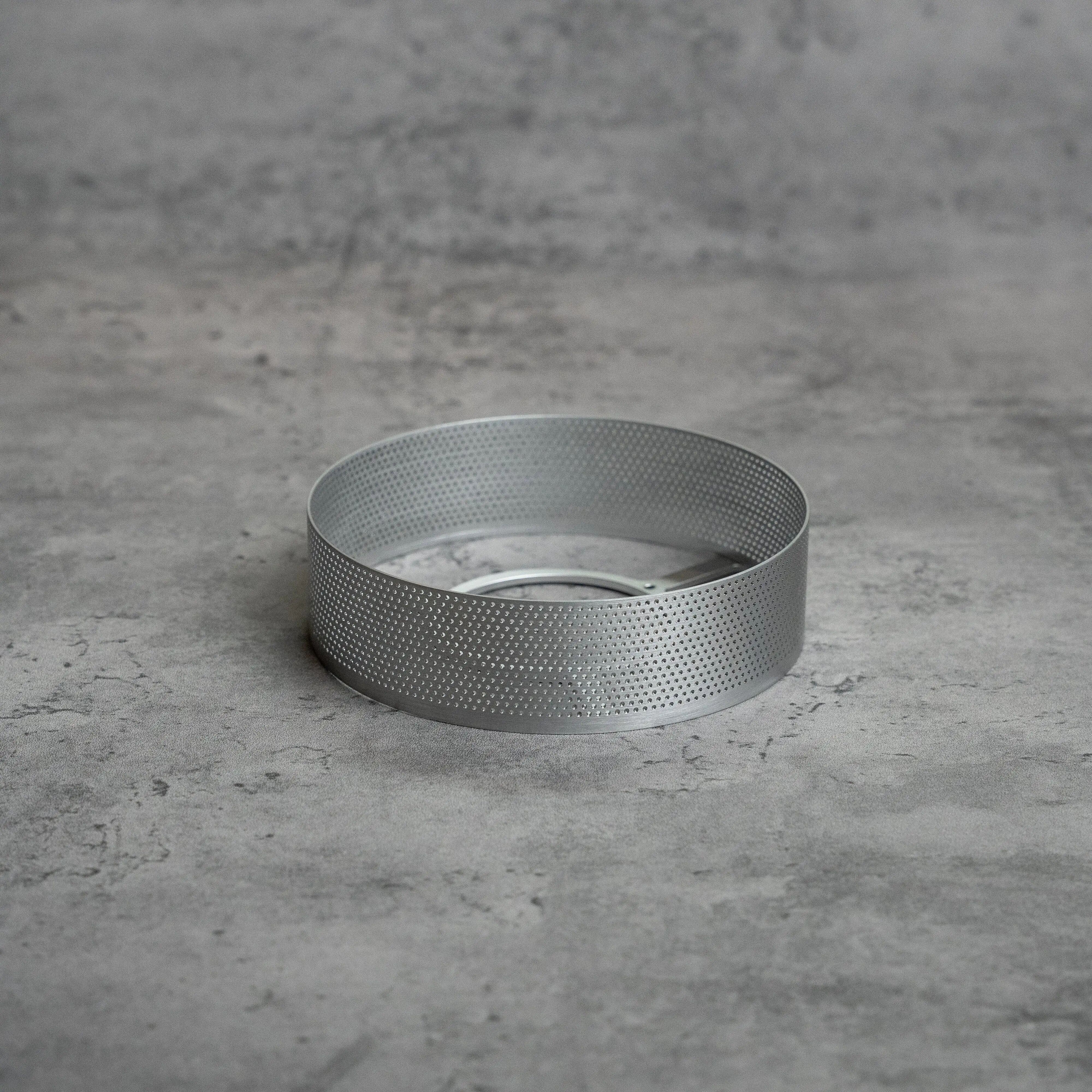 银色 ECHO LAMP Perforated Ring 放在灰色台面上